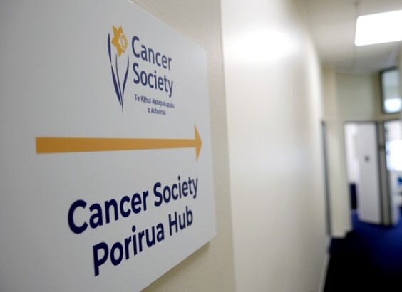 Cancer Society Porirua Hub sign with office in background.